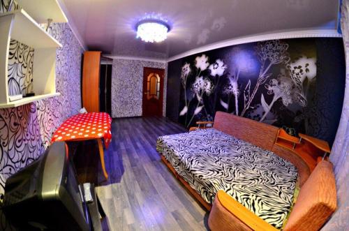 ケメロヴォにあるVip Hotel - Kemerovo Sportivnaya 38のベッドルーム1室(ベッド1台付)、壁画が備わります。