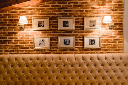 a brick wall with framed pictures on a wall at Green House Hotel & Restaurant in Tirana