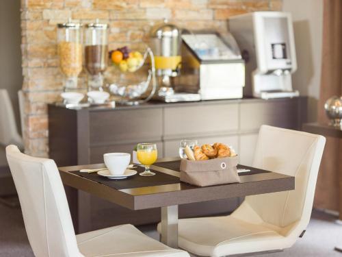 ein Tisch mit einer Schüssel Brot und einem Glas Orangensaft in der Unterkunft Hôtel Marina Corsica in Porto-Vecchio