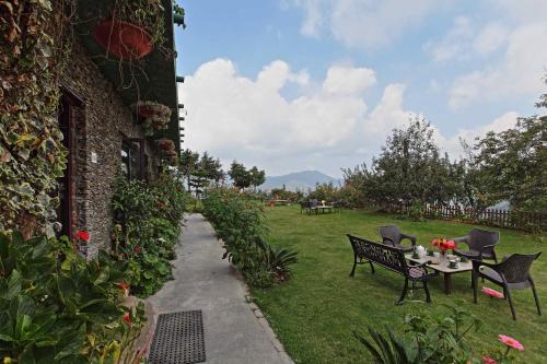 a patio with a table and chairs in a yard at Cedar Lodge By Aahma in Rāmgarh