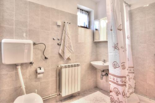 y baño con aseo y lavamanos. en Apartments Grozdana, en Baška