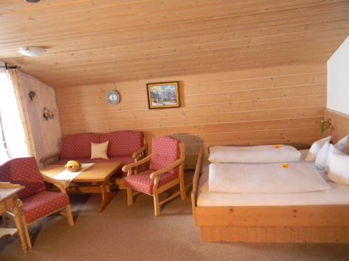 een kamer met 2 bedden en een tafel en stoelen bij Landhaus Spielmannsau in Oberstdorf