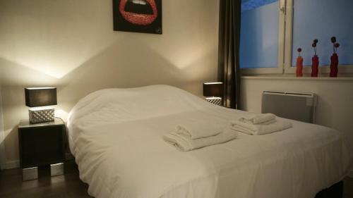 a bedroom with a white bed with towels on it at Little Suite - Prisca in Lille