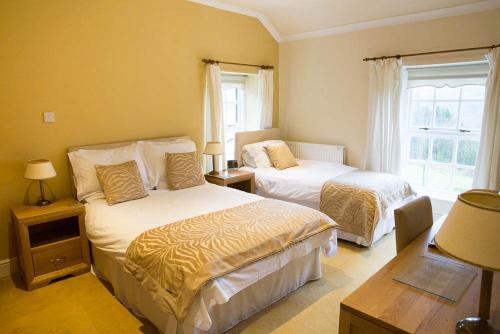 a hotel room with two beds and a window at Llwyn Onn Guest House in Merthyr Tydfil