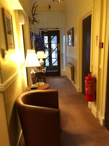 a hallway with a chair and a fire hydrant at Crown Guest House in Aberdeen