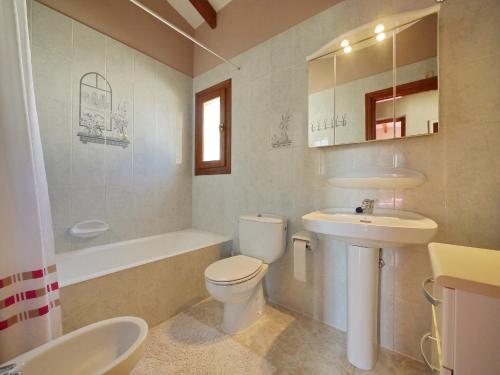 a bathroom with a toilet and a sink and a tub at Villa Salinas in Calpe