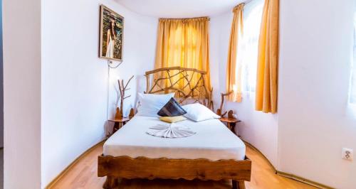 a bedroom with a bed with white sheets and a window at Castelul de Vis in Petroşani