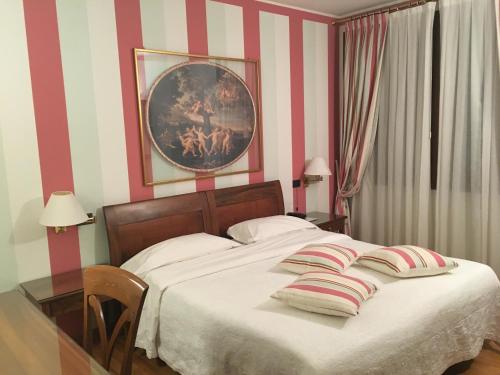 a bedroom with a large bed with striped walls at hotel alla busa in Noventa Vicentina