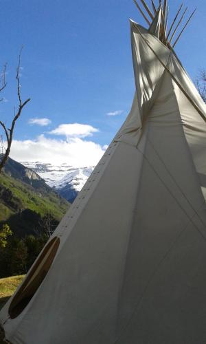 a close up of a white tent with mountains in the background at Tipis nature in Gavarnie