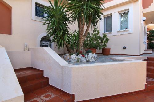 a courtyard with a palm tree and a fountain at Oasis Pool House by GHH in Lagonissi