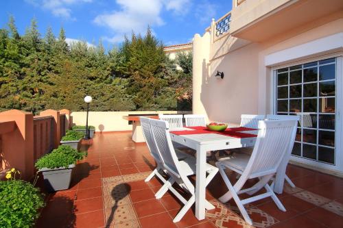 a white table and chairs on a patio at Oasis Pool House by GHH in Lagonissi