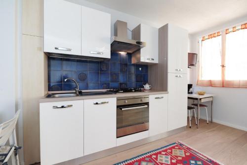 une cuisine avec des armoires blanches et un évier dans l'établissement Blue Lagon Five Stars Holiday House, à Nice