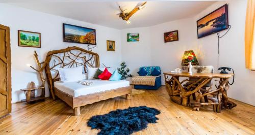 a bedroom with a bed and a desk and a table at Castelul de Vis in Petroşani
