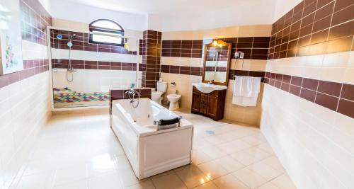 La salle de bains est pourvue d'une baignoire, de toilettes et d'un lavabo. dans l'établissement Castelul de Vis, à Petroşani