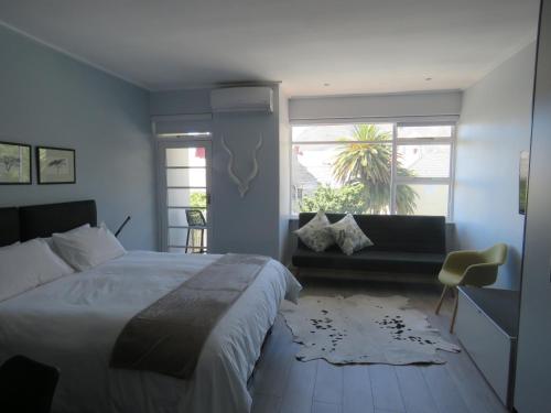 sypialnia z dużym łóżkiem i oknem w obiekcie Oranjehof Studios w Kapsztadzie
