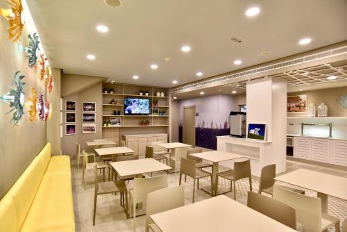 a restaurant with tables and chairs and a tv at TC Lindamar in Las Palmas de Gran Canaria