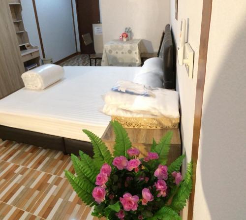a bedroom with a bed with pink flowers on it at Tamruethai House - ตามฤทัยเฮาส์ in Chiang Mai
