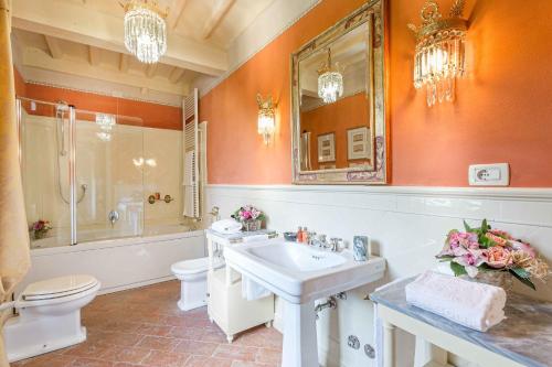 a bathroom with a sink and a toilet and a mirror at Coselli 's Collection. Luxury Villas Rental in Capannori