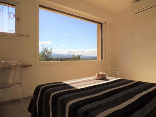 Un dormitorio con una cama y una ventana grande. en Mas Les Romarins, en Montesquieu