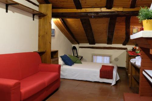 1 dormitorio con 1 cama y 1 sofá rojo en Castiglione Lovely Mansarda en Bolonia