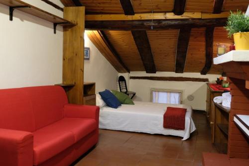 ein Schlafzimmer mit einem Bett und einem roten Sofa in der Unterkunft Castiglione Lovely Mansarda in Bologna