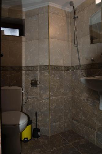 a bathroom with a shower and a toilet and a sink at Guest House Ivan in Cherni Osŭm