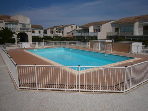une grande piscine entourée d'une clôture. dans l'établissement Les Soleils de Pontaillac, à Vaux-sur-Mer