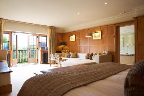 a hotel room with a large bed and a living room at Gidleigh Park- A Relais & Chateaux Hotel in Chagford