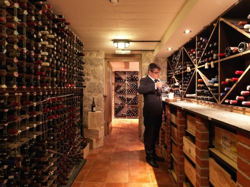 a man standing in a wine cellar with a bunch of wine bottles at Gidleigh Park- A Relais & Chateaux Hotel in Chagford