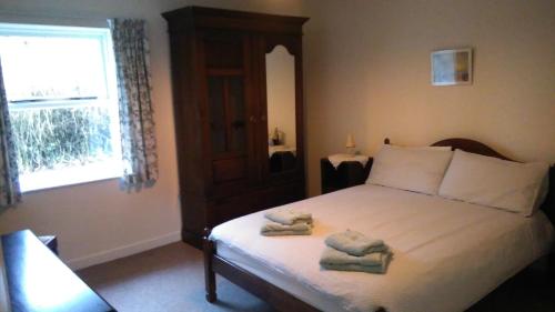 a bedroom with a bed with towels on it at Ardtarmon Garden Cottage in Sligo