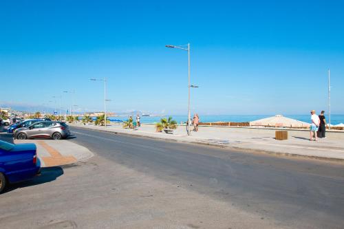 a street with cars parked on the side of a beach at Sunny Beach Apartments in Rethymno Town