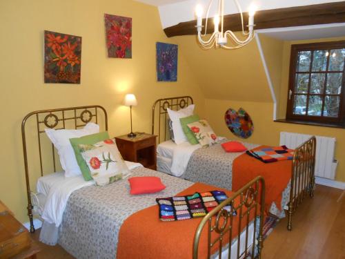 a bedroom with two beds and a chandelier at B&B La Ferme des Bordes in Pontlevoy