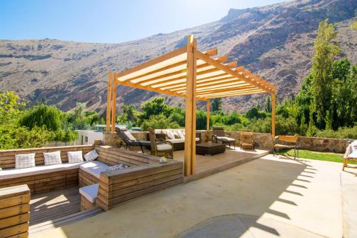 a deck with a pergola with a view of a mountain at Aldea del Valle - Elqui Villas, Pisco Elqui in Pisco Elqui