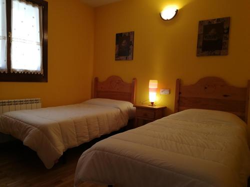 バルエラにあるTres Dormitorios Barruera Immovallの黄色い壁の客室内のベッド2台