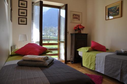 スコペッロにあるValsesia, Monterosa, ampio bilocale, piscina, tennisのベッドルーム1室(ベッド2台付)、窓付きのドアが備わります。