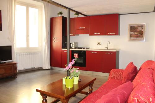 a living room with a red couch and a table at Art Apartment Santo Spirito Matteo in Florence