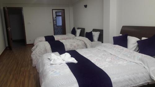 a group of four beds in a room at Hotel Bhaktapur Inn in Bhaktapur