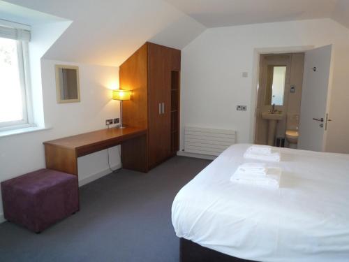 a hotel room with a bed and a desk and a window at Castlemartyr Holiday Mews 3 bed in Castlemartyr