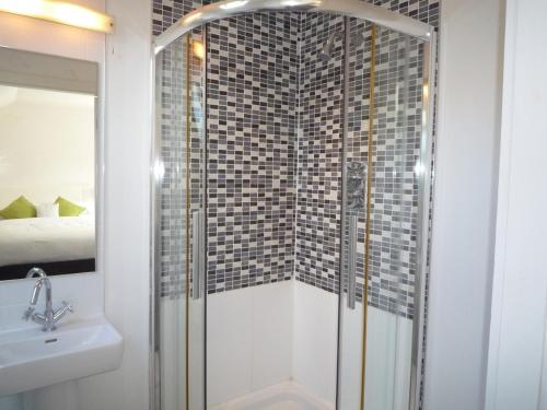 a bathroom with a shower with a sink and a toilet at Castlemartyr Holiday Mews 2 bed by Trident Holiday Homes in Castlemartyr
