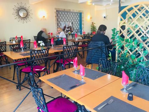 バスティアにあるHôtel Sampieroのピンクのキャンドルが置かれたテーブルと椅子が備わるレストラン