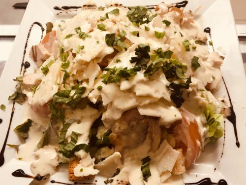 a plate of food with cheese and greens on it at Hôtel Sampiero in Bastia