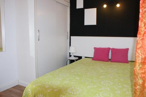 エンプリアブラバにあるGoldhome - Sylviaのベッドルーム1室(緑のベッド1台、ピンクの枕2つ付)