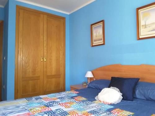 a blue bedroom with a bed and a wooden door at Benicanena in Gandía