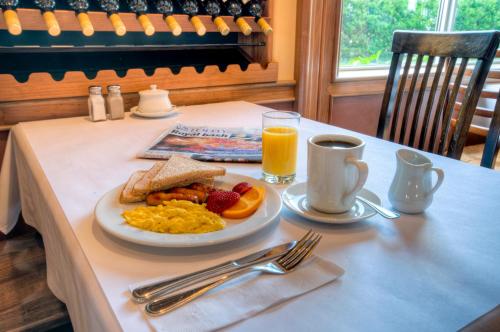 a table with a plate of breakfast food and a glass of orange juice at Best Western Plus Stoneridge Inn & Conference Centre London Ontario in London