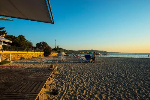 a beach with chairs and people on the sand at Iris Hotel & Spa in Canakkale