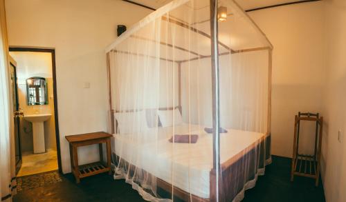 1 dormitorio con cama con dosel en una habitación en Peak House, en Hiriketiya