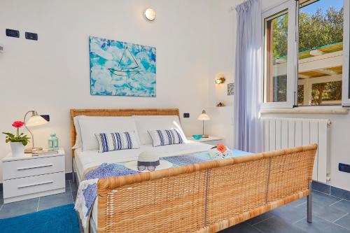 a bedroom with a large bed and a window at Villa Ginestra - Scopello-Villas in Scopello