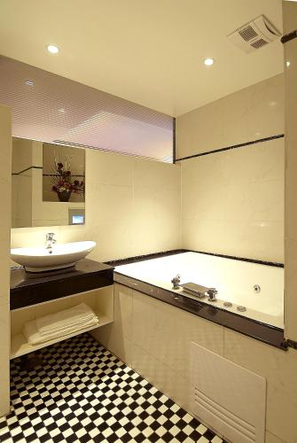 a bathroom with a sink and a bath tub at Qi Hai Motel in Zhunan