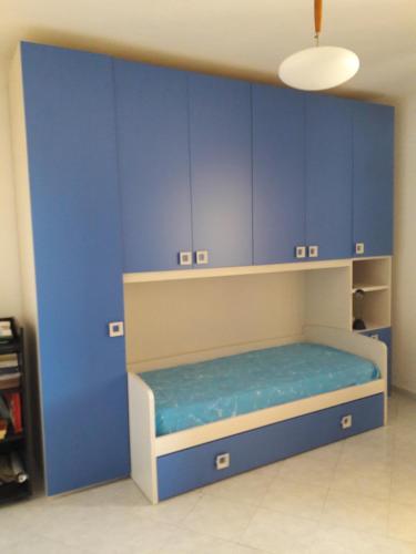 a room with blue cabinets and a bed in it at camera zona policlinico/università in Monserrato