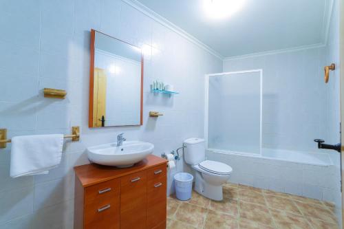 a bathroom with a sink and a toilet and a mirror at Apartamentos Ribera del Júcar in Alcalá del Júcar